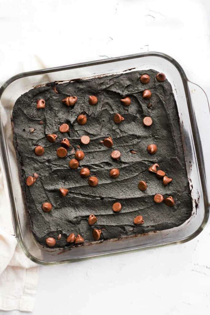 vegan brownies with pumpkin topped with chocolate chips in baking dish.