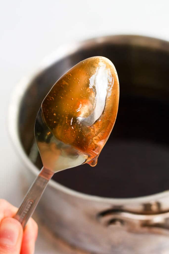 vegan teriyaki sauce coating the back of a silver spoon.