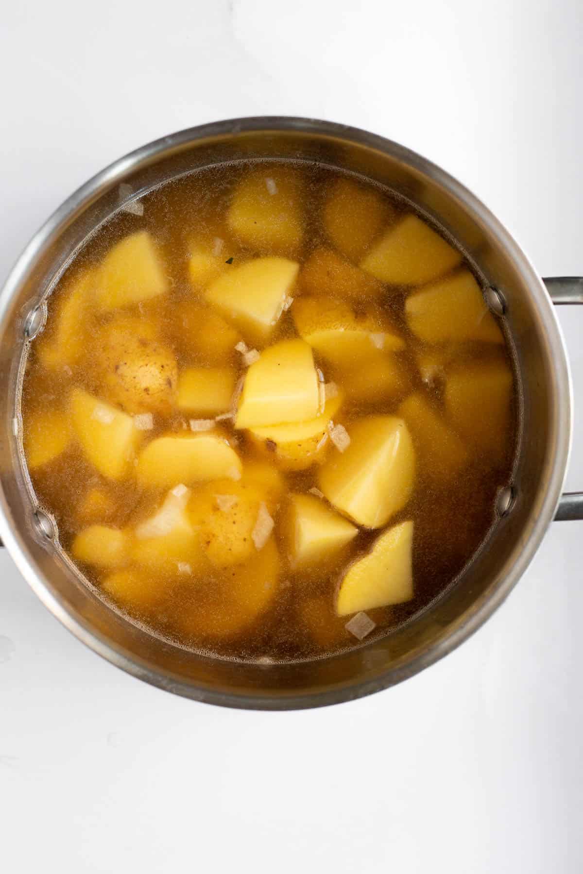 potatoes and broth in a silver pot.