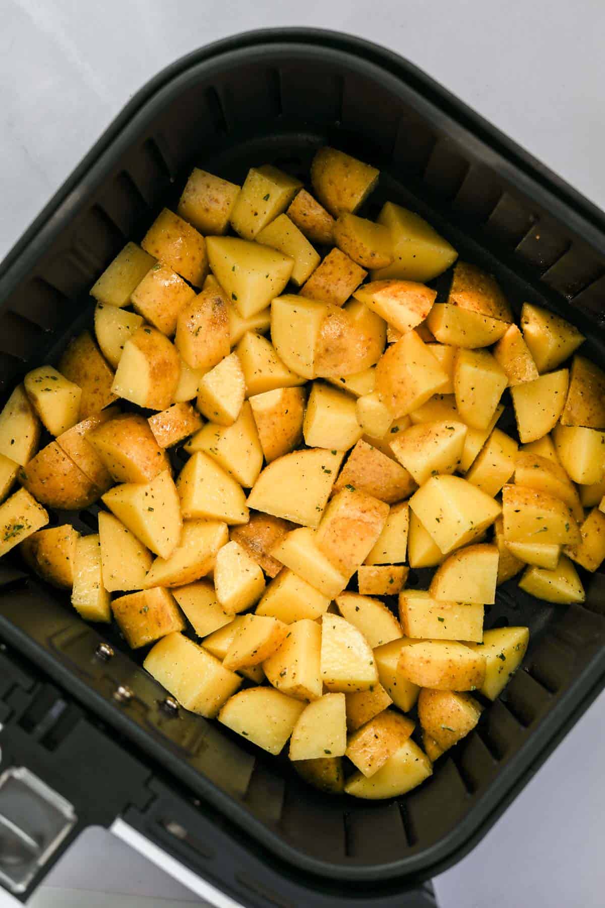 yukon gold potatoes in an air fryer basket.