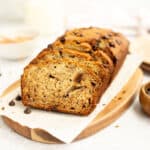dairy free banana bread with chocolate chips on wood board lined with parchment paper.