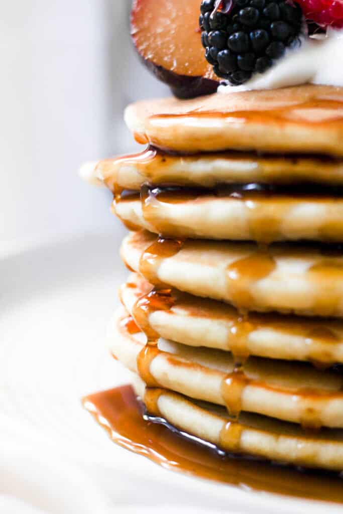 maple syrup dripping down a stack of pancakes.