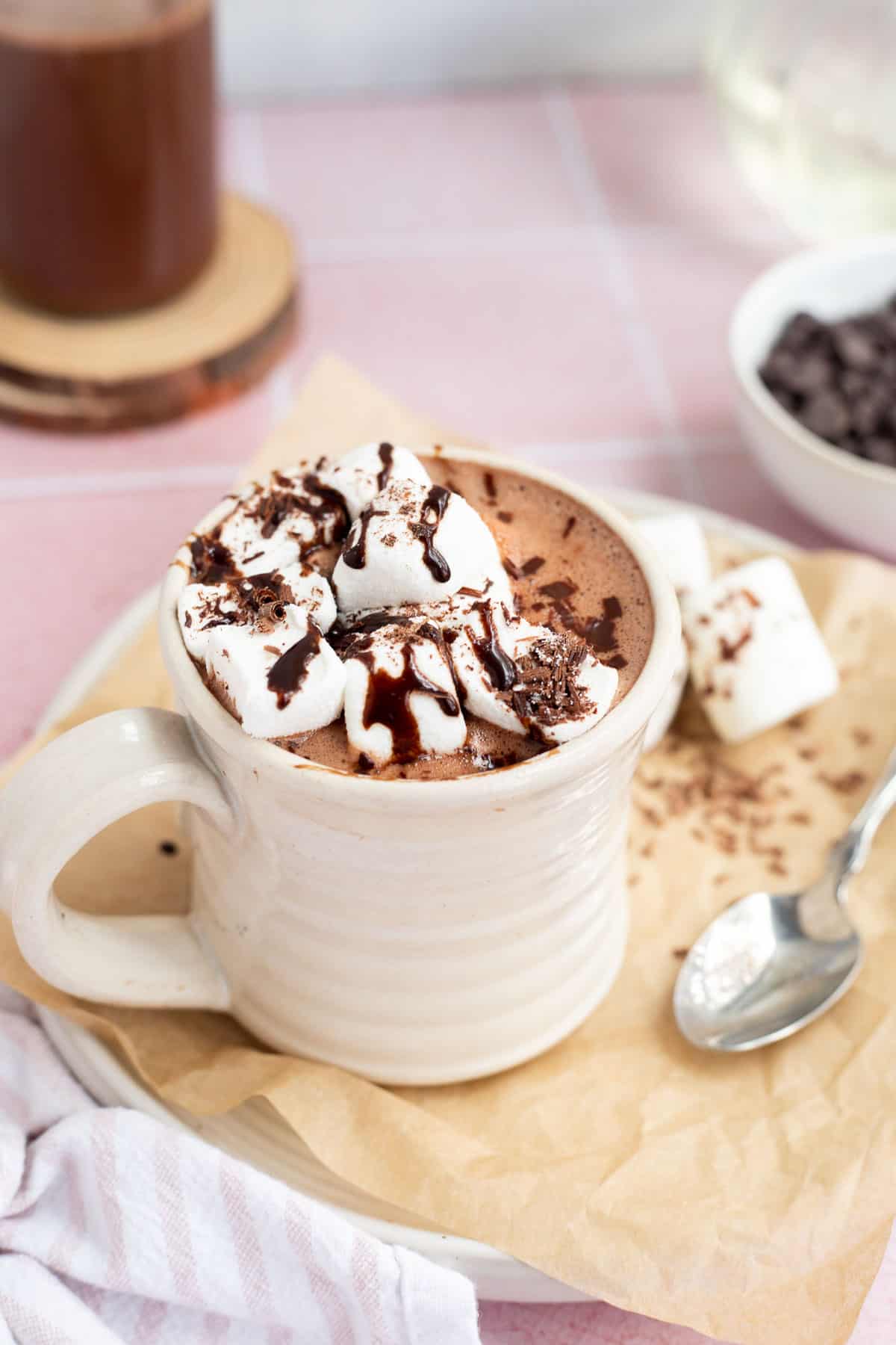 protein hot chocolate in a ceramic mug with marshmallows and chocolate sauce.