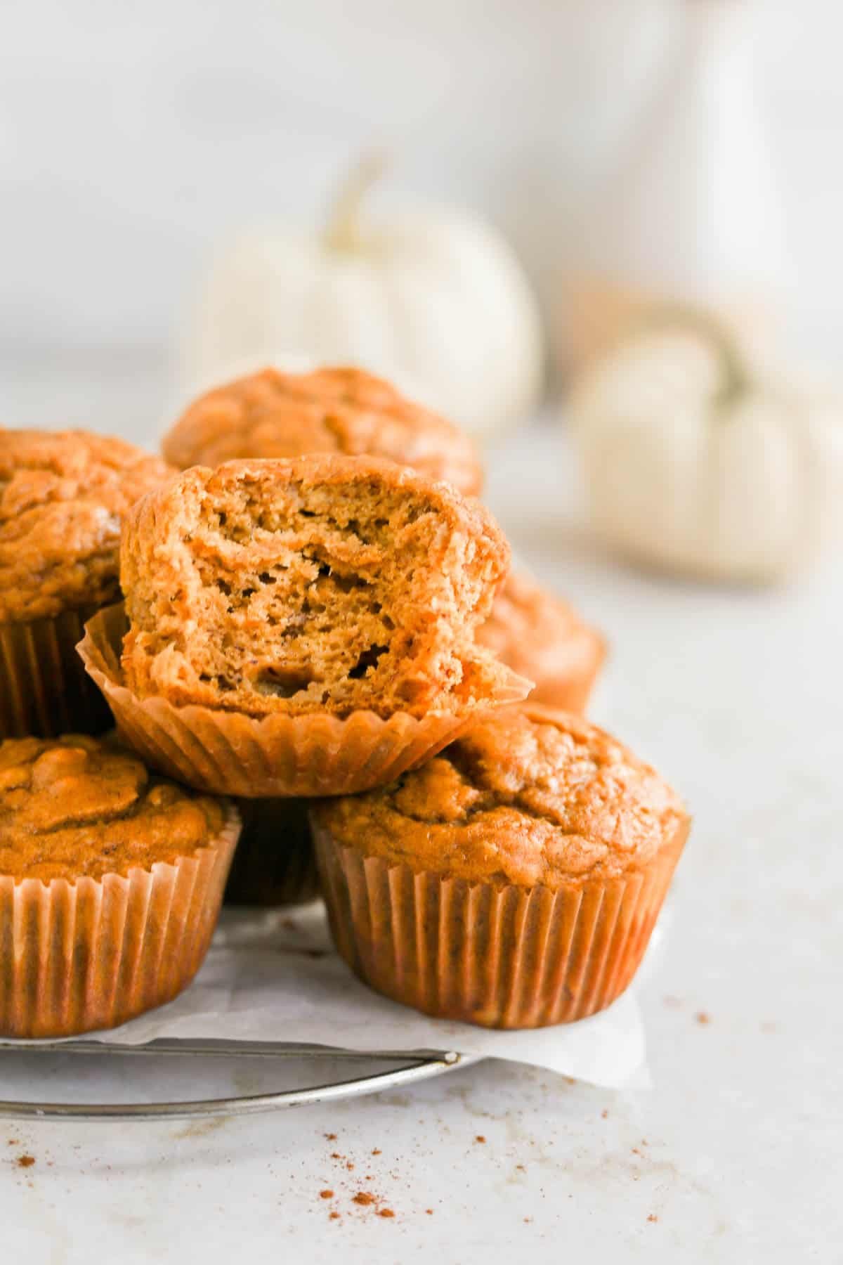 pumpkin banana muffins piled on top of each other with a bite in one.