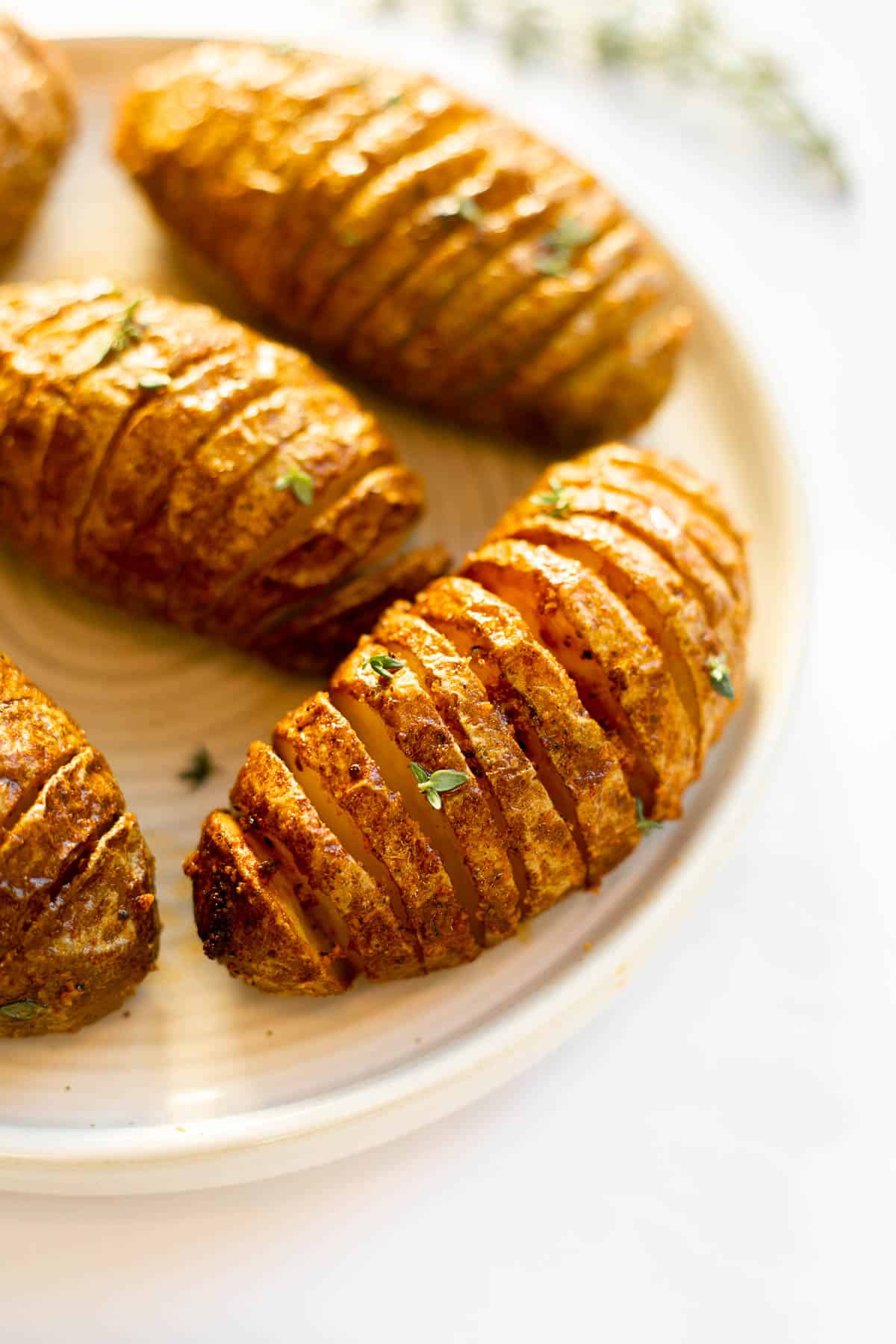 air fryer hasselback potatos on a white plate.