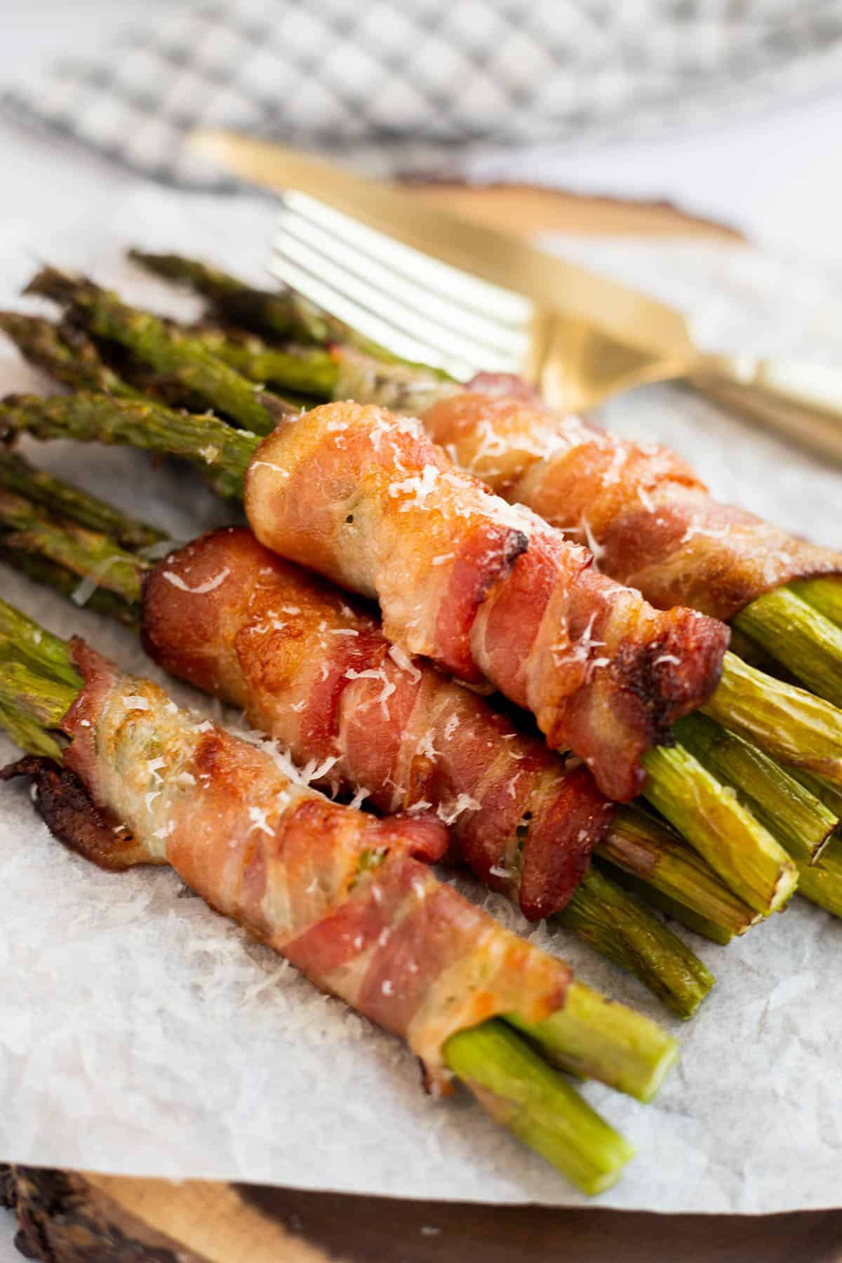 air fryer bacon wrapped asparagus on parchment paper.