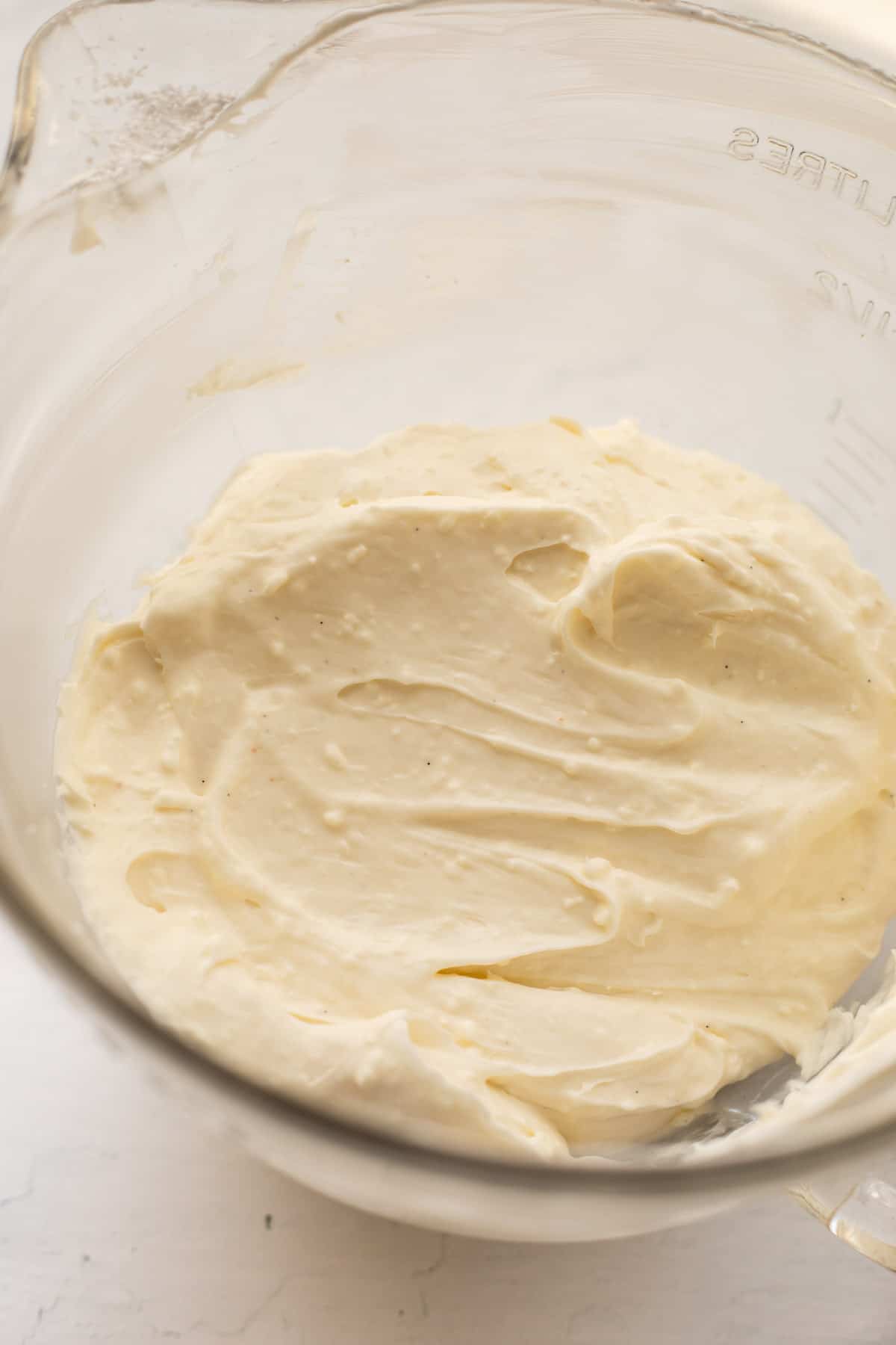 no butter cream cheese frosting in a glass bowl.