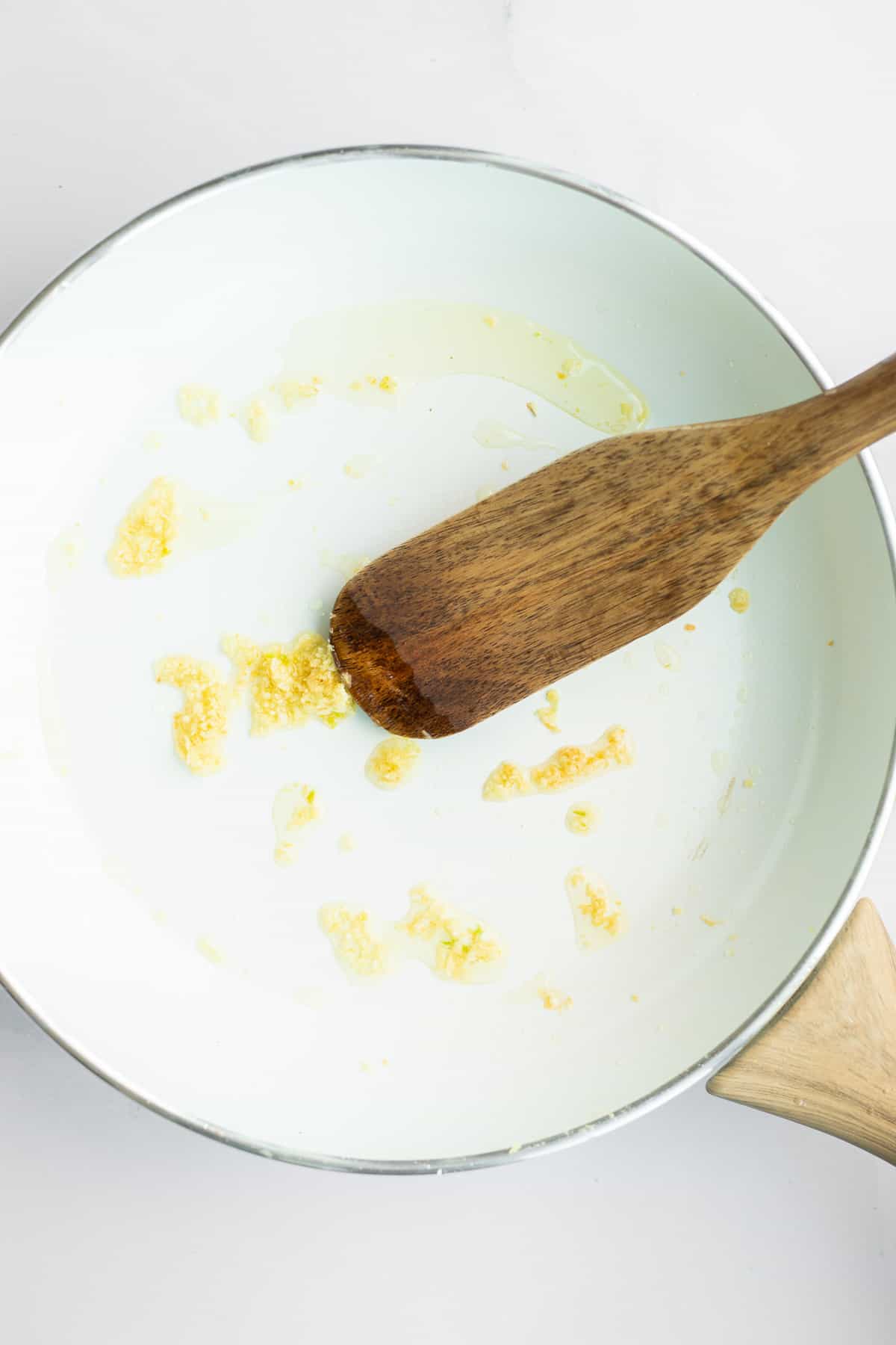 sauteed garlic in white pan.