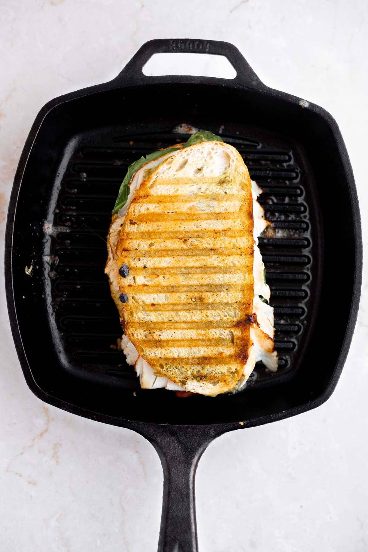 grilled turkey pesto sandwich in a cast iron pan.