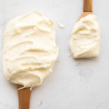 cream cheese frosting without butter on two wooden spatulas.