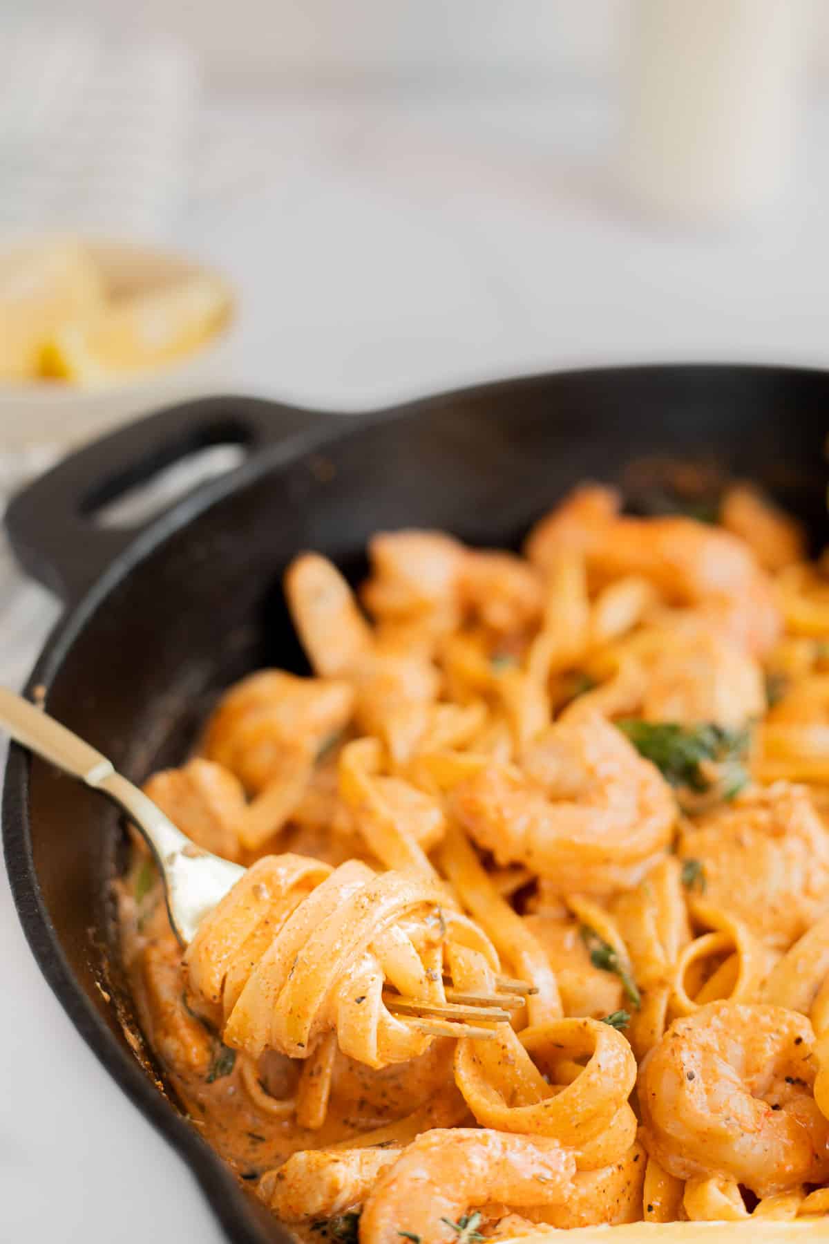 gold fork twirled with fettuccini pasta in a creamy Cajun sauce.