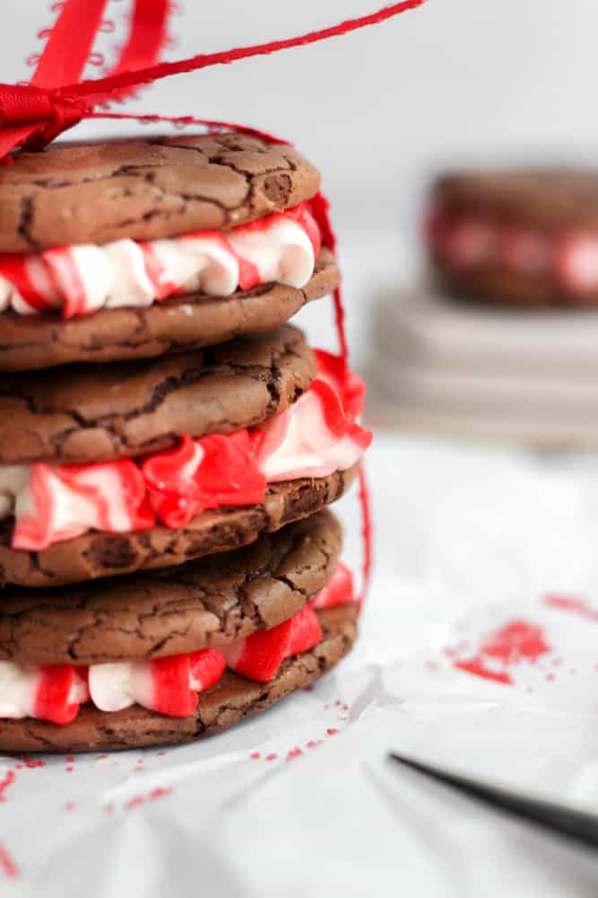 three peppermint brownie cookies stacked on each other and tied with a red ribbon.