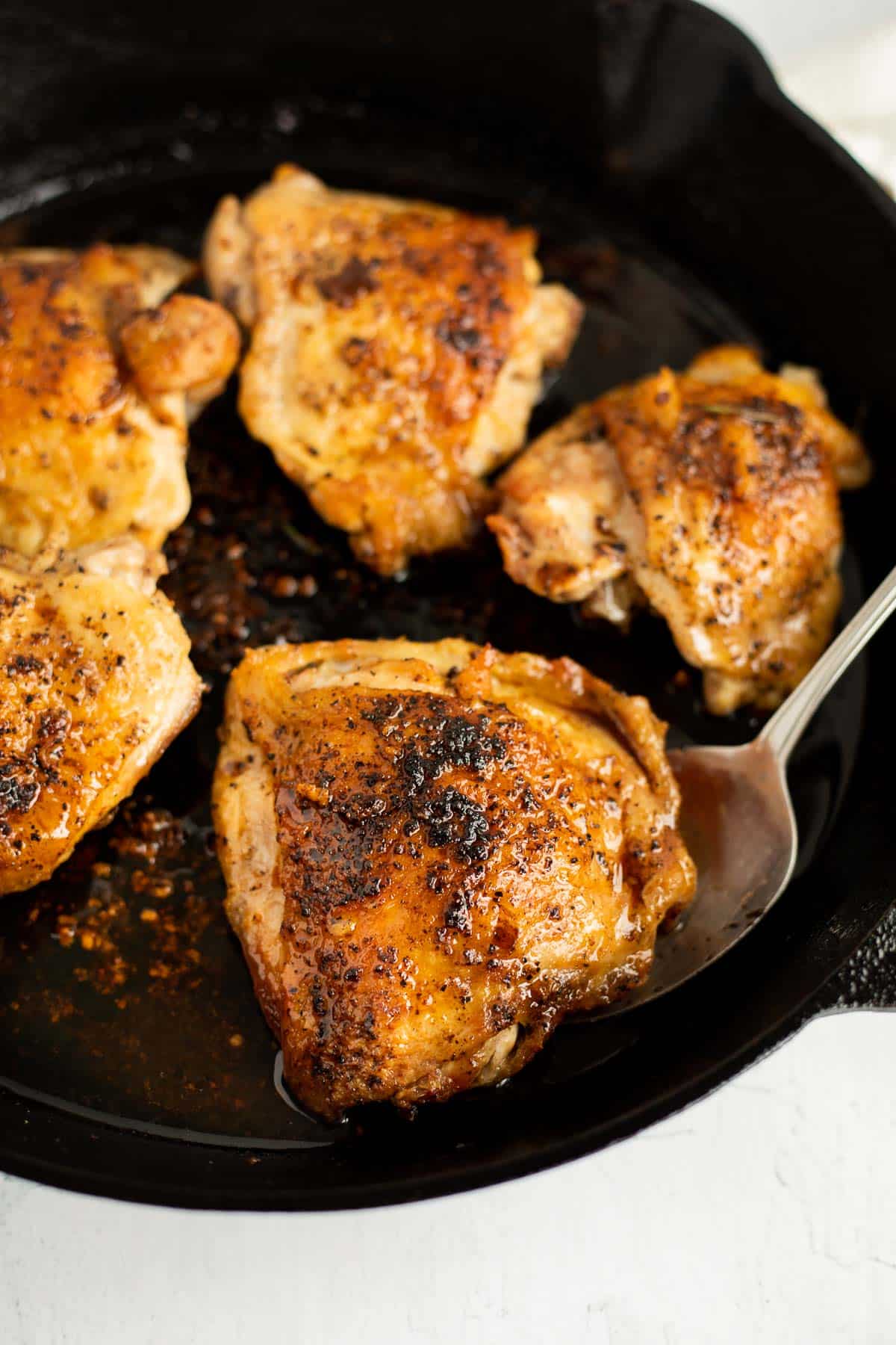 pan seared chicken thighs in a cast iron pan.