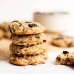 stack of 4 vegan oatmeal cookies on white backdrop.