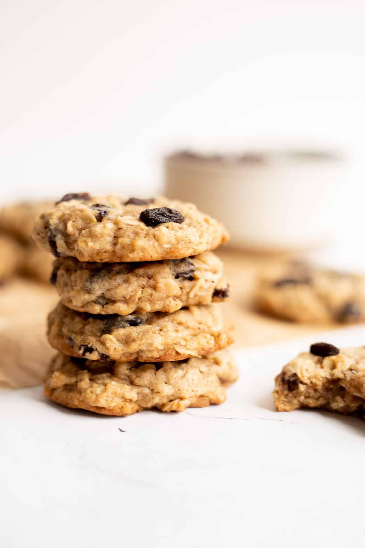 stack of 4 vegan oatmeal cookies on white backdrop.