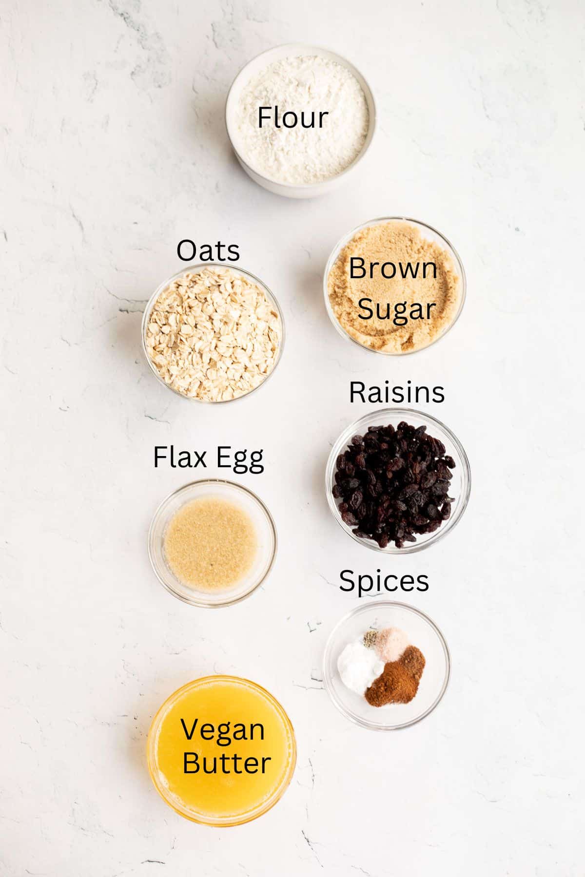 ingredients for vegan oatmeal raisin cookies labeled with black text.
