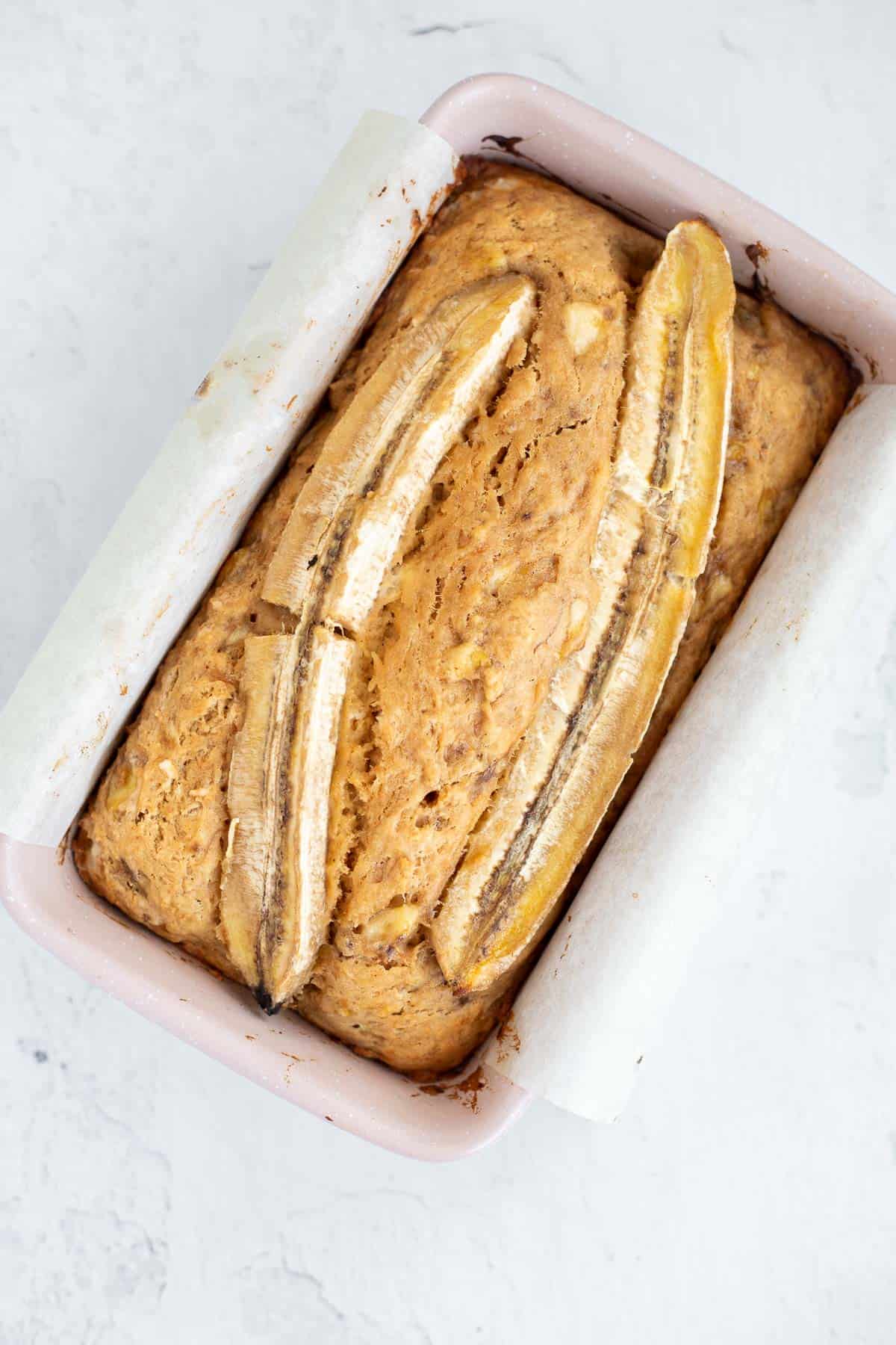 4 ingredient banana bread baked in a pink loaf pan.