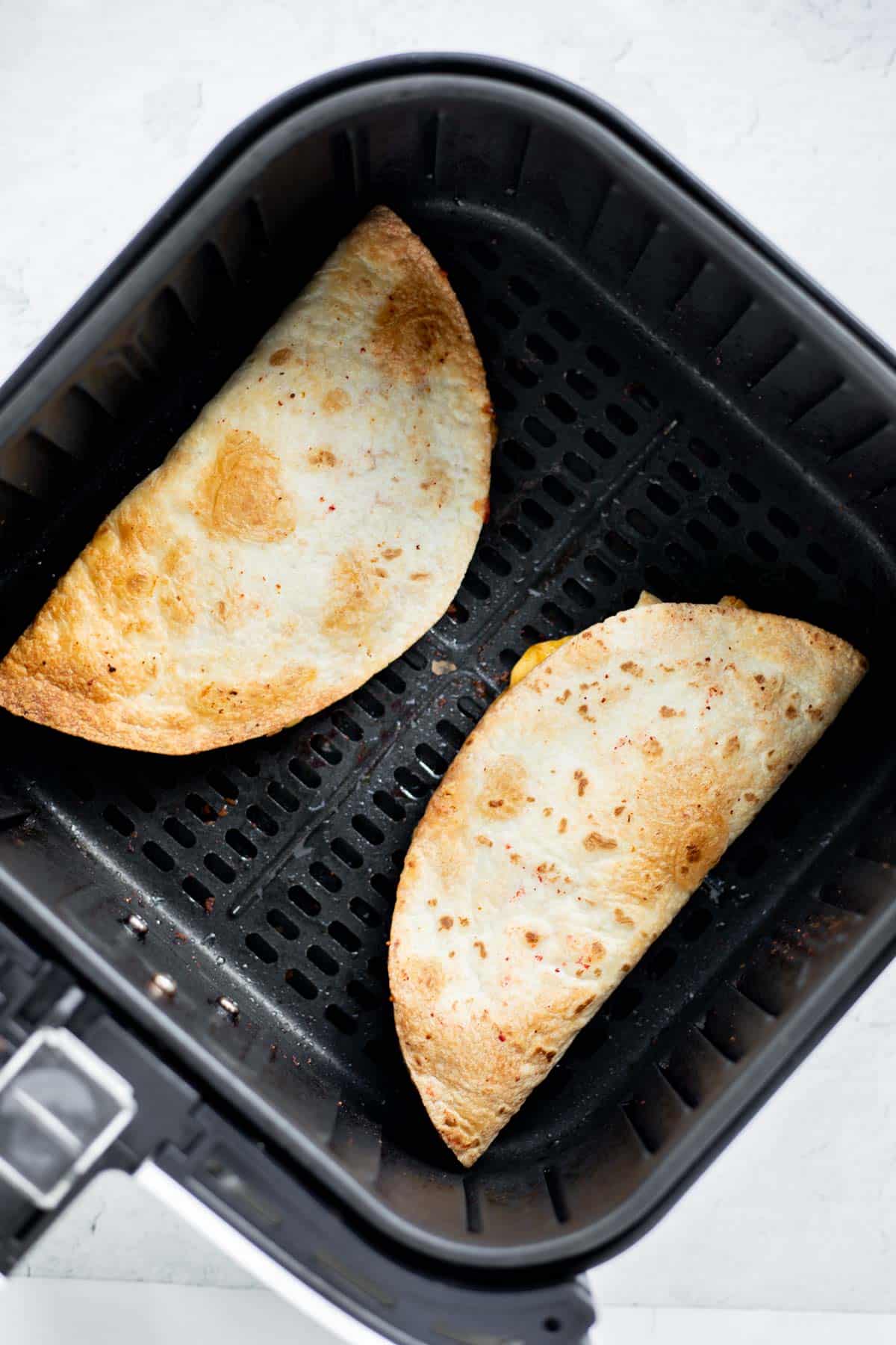 quesadillas cooked in air fryer basket.