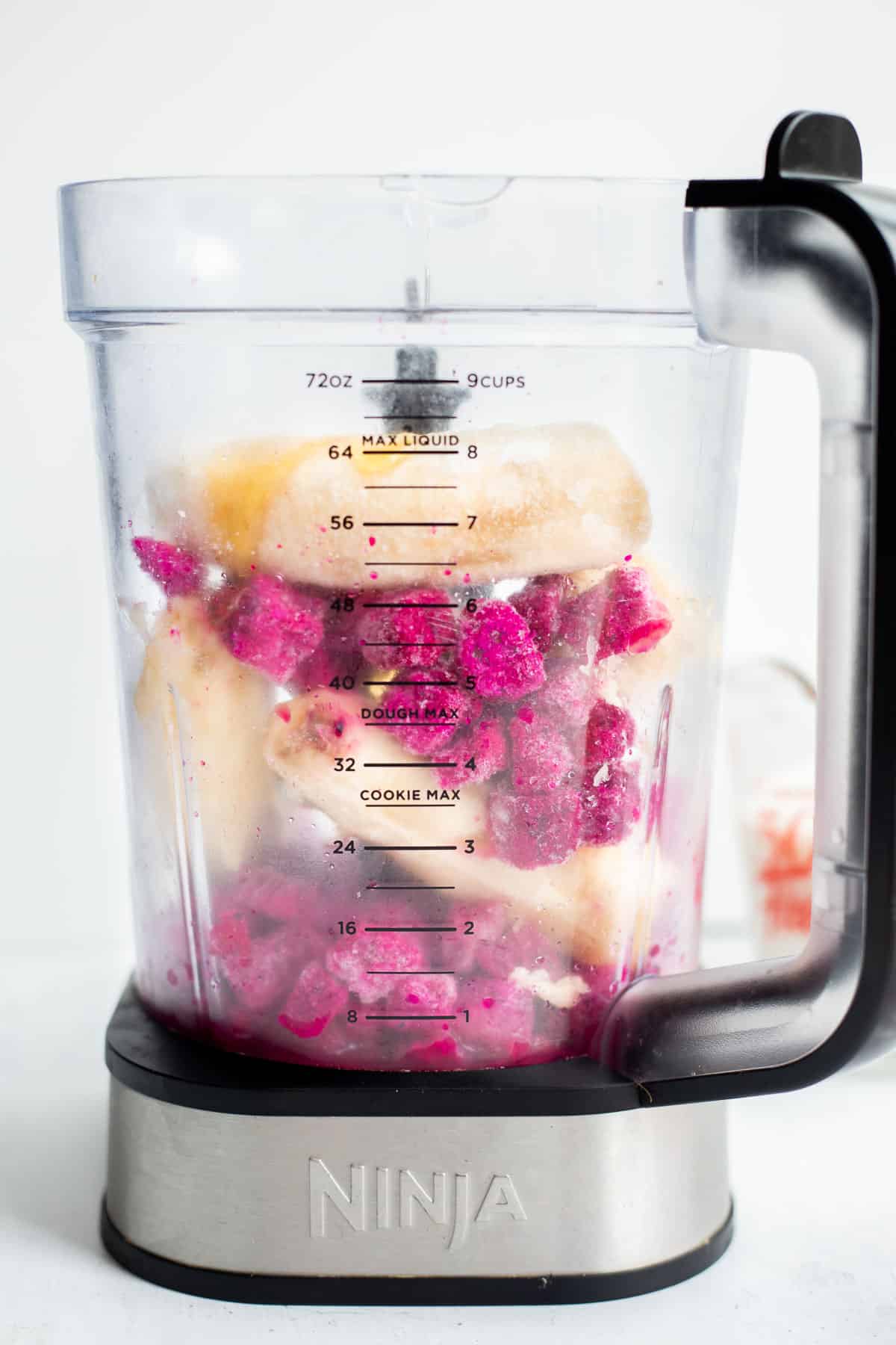 frozen pitaya and bananas layered in a blender cup.
