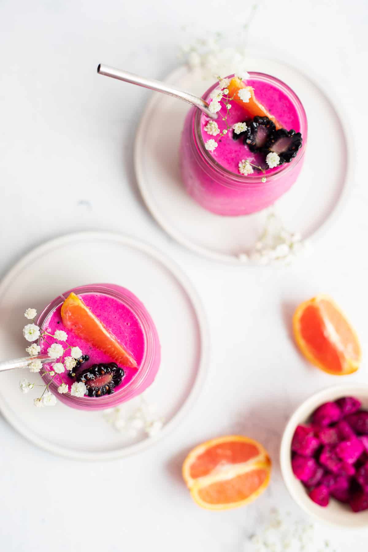 overhead photo of two dragon fruit smoothies in glass jars.