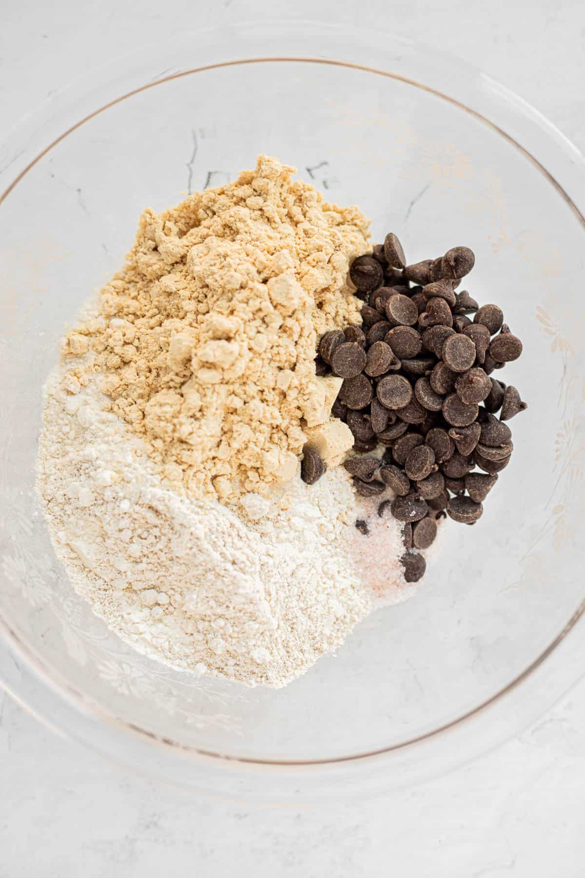 flour, protein powder, chocolate chips, and salt in a glass bowl.