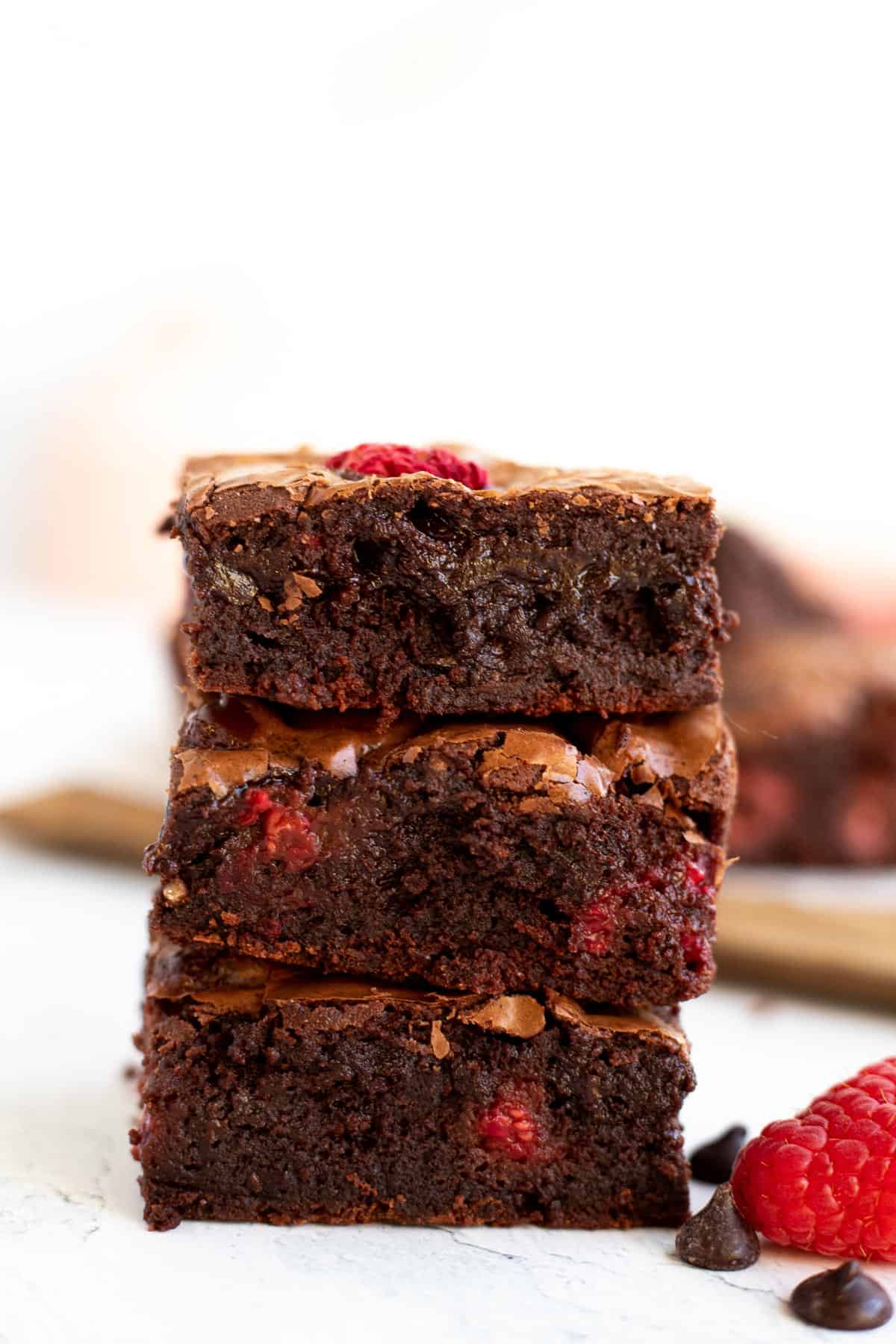 3 raspberry brownies stacked on top of each other.