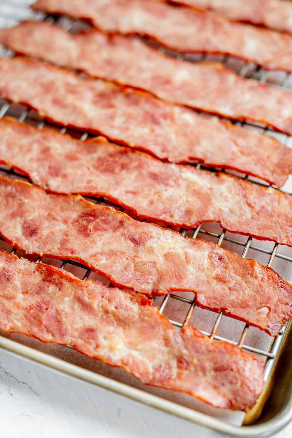 slices of oven baked turkey bacon on a wire rack.