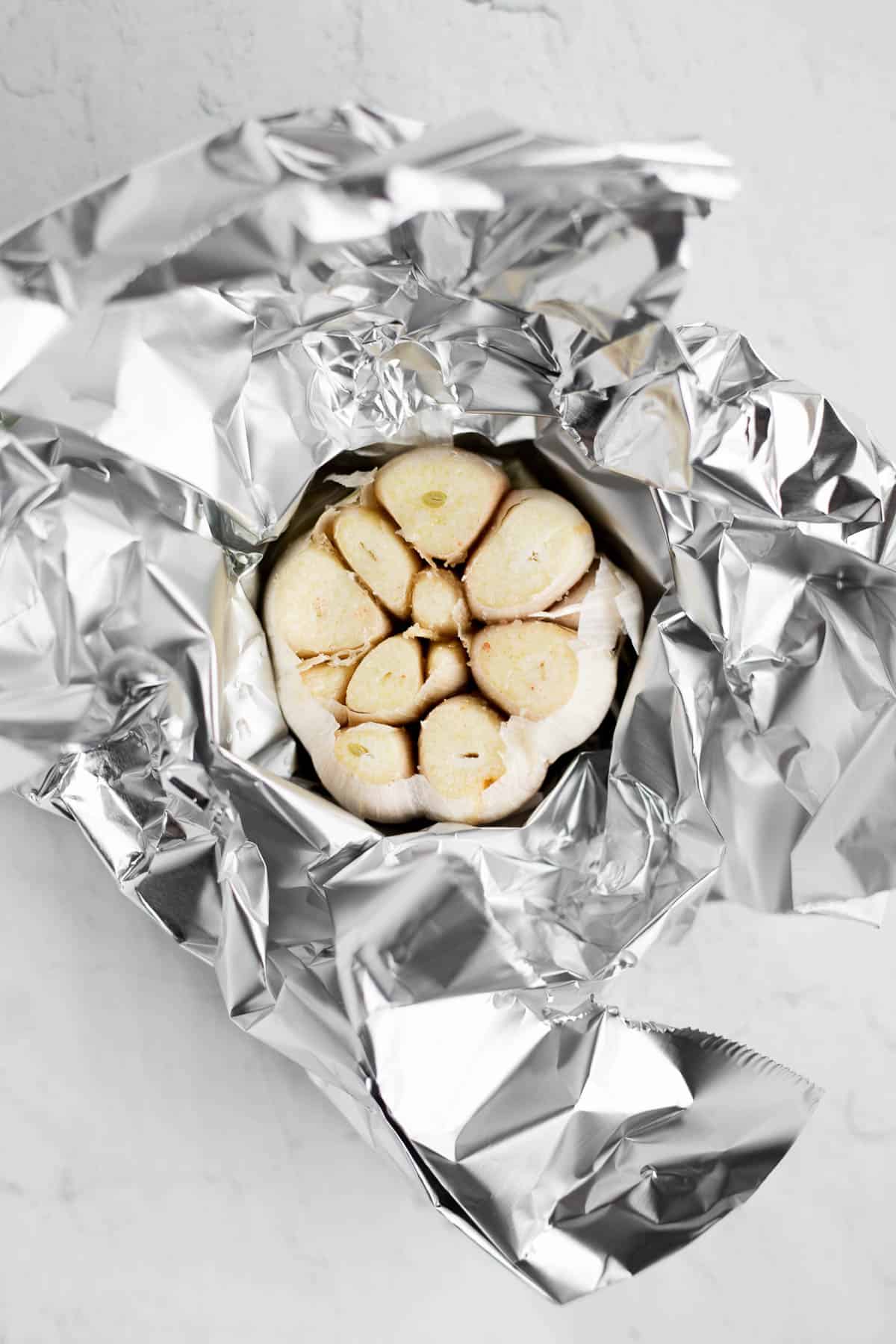 whole bulb of garlic wrapped in aluminum foil.