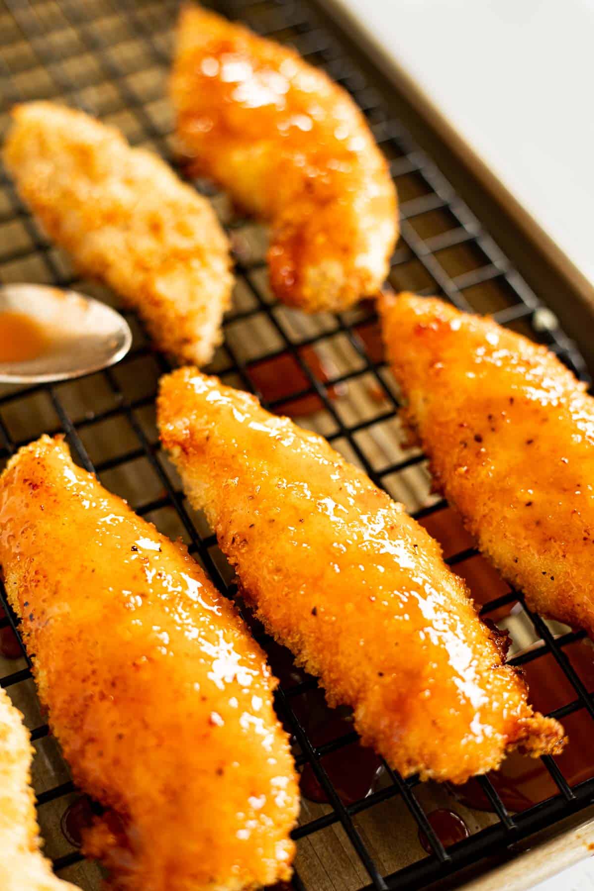 chicken tenders with hot honey sauce on a wire rack.