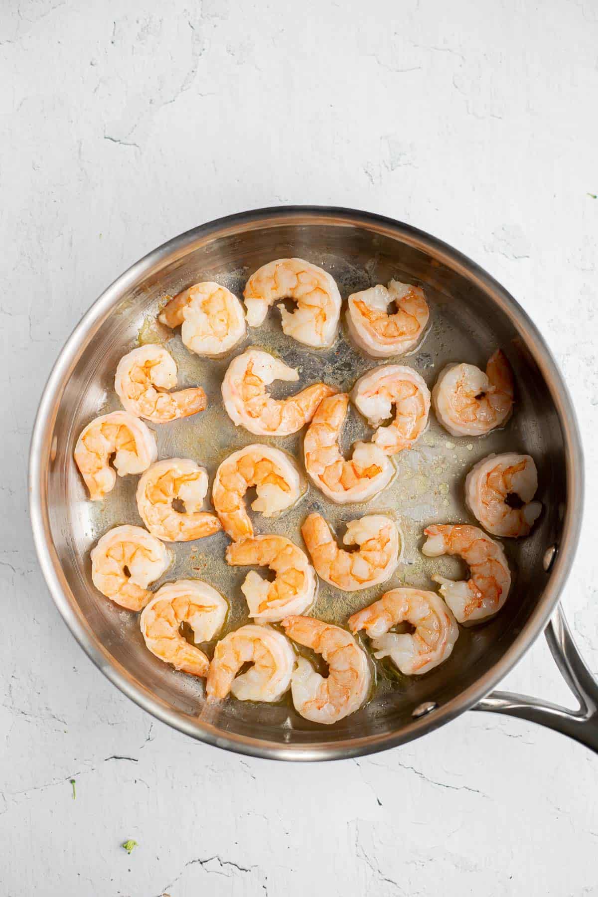 seared shrimp in a stainless steel pan.
