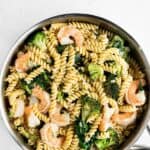 pasta with shrimp, broccoli, and a cream sauce in a stainless steel pan.