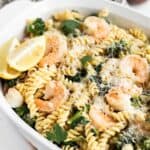 pasta with shrimp, broccoli, and lemon in a white serving dish.