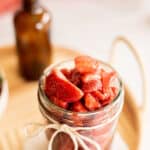 homemade strawberry compote in a glass jar with a ribbon.