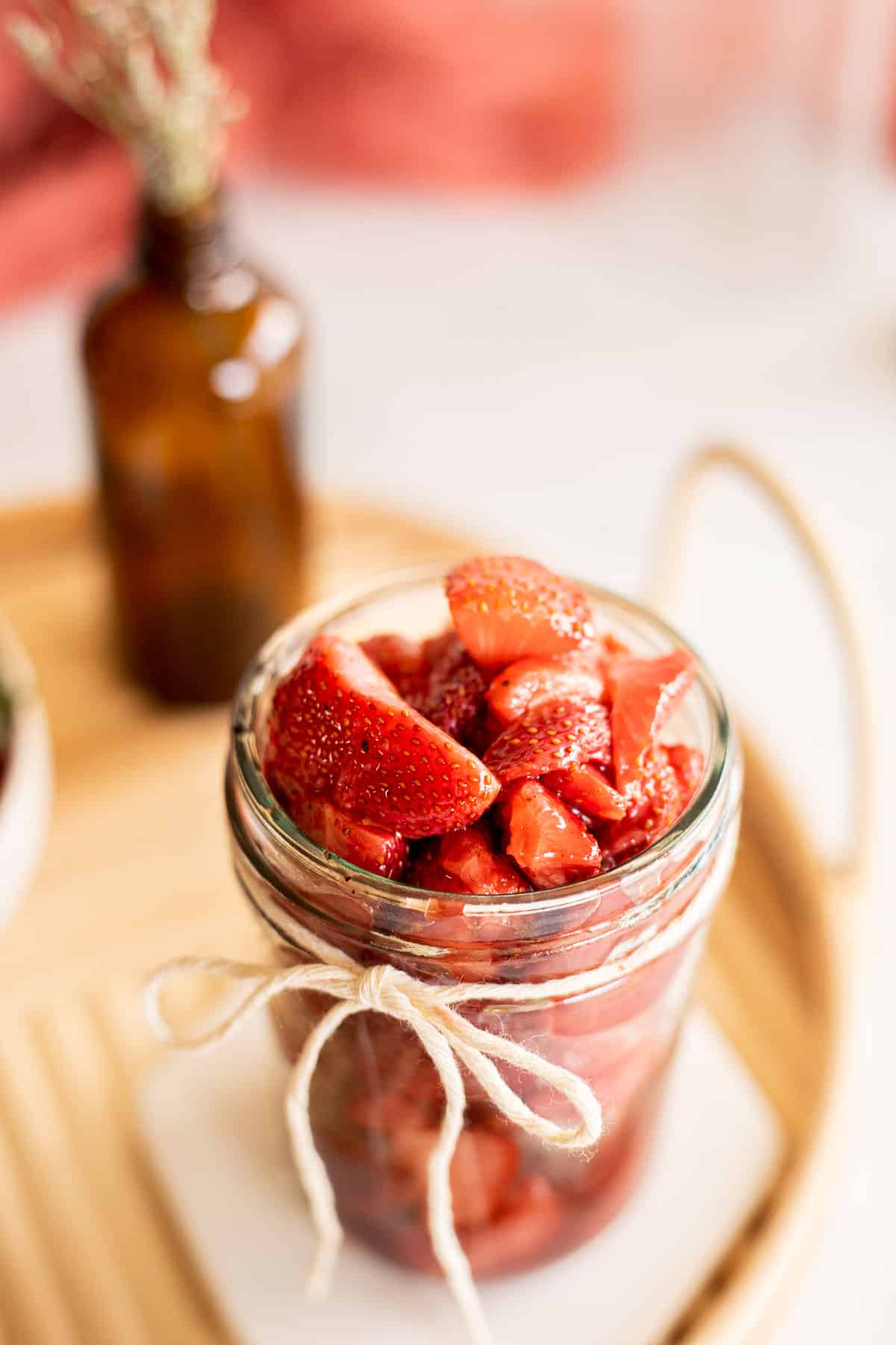 homemade strawberry compote in a glass jar with a ribbon.