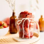 strawberry compote in a glass jar with a ribbon.
