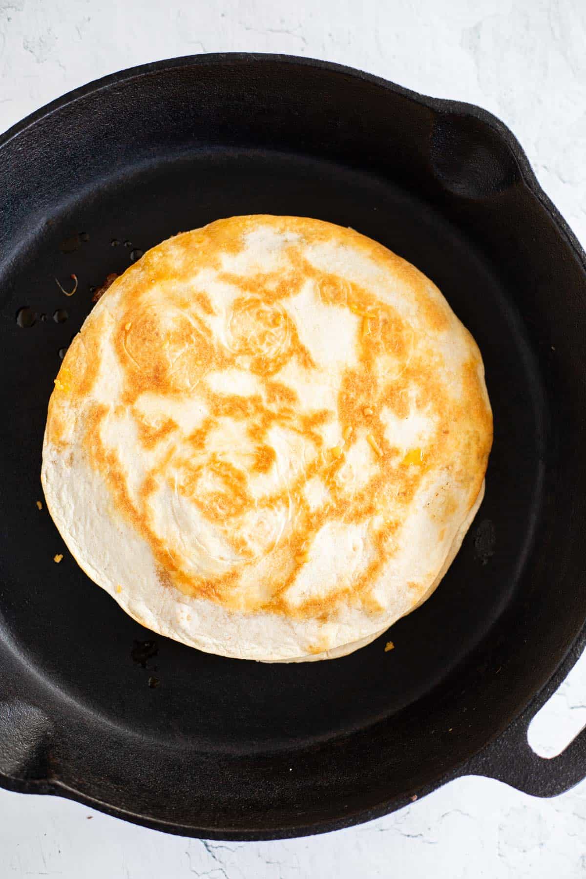 browned tortilla in a cast iron pan.