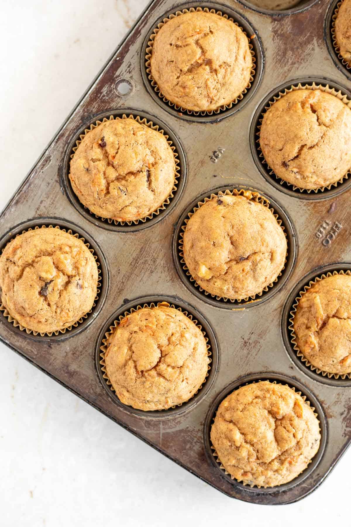 baked carrot cake muffins in a muffin tin.