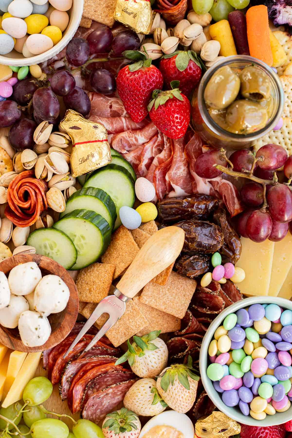 and Easter Charcuterie Board with fruit, veggies, meat, cheese, and candy.