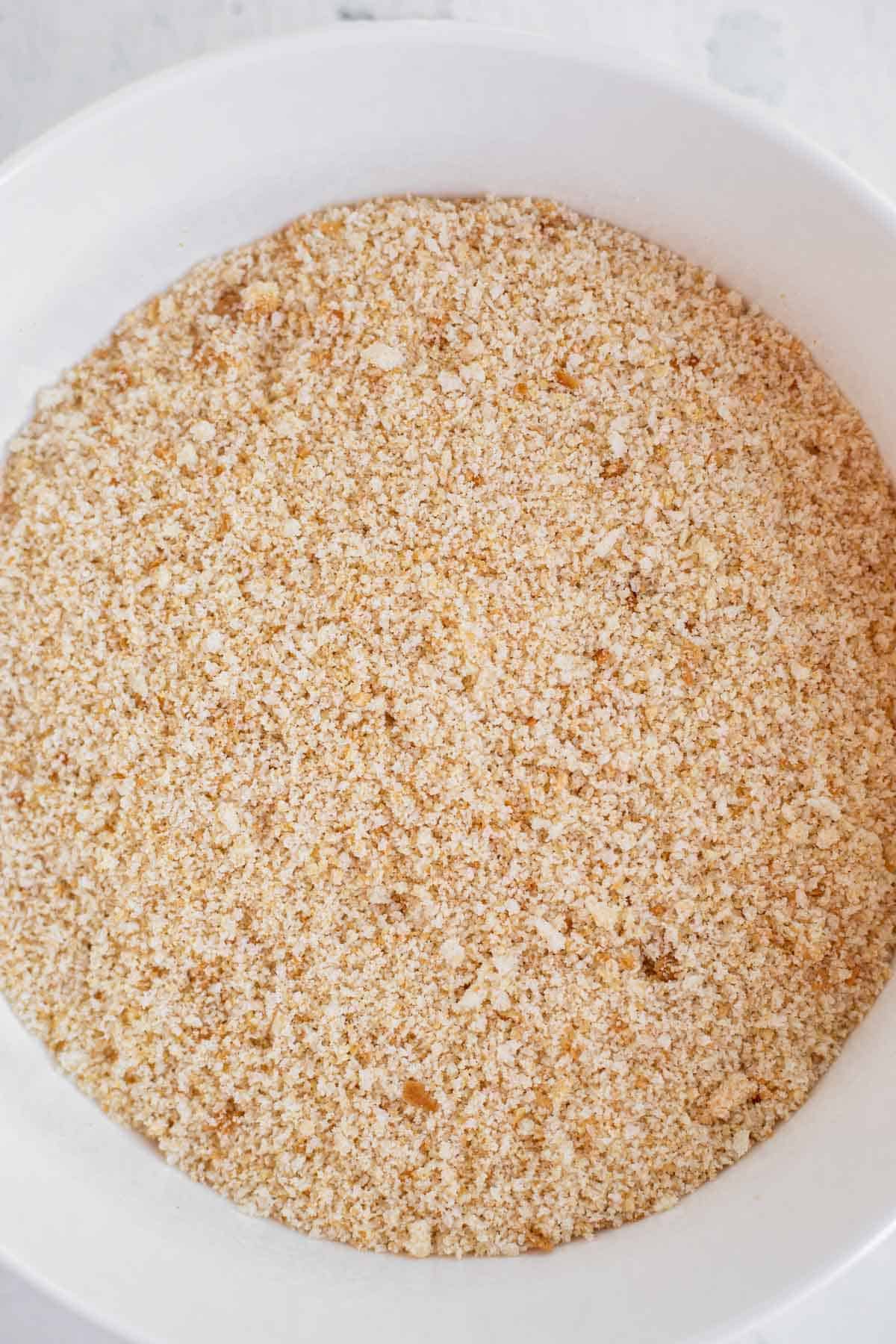 bread crushed into crumbs into a white bowl.