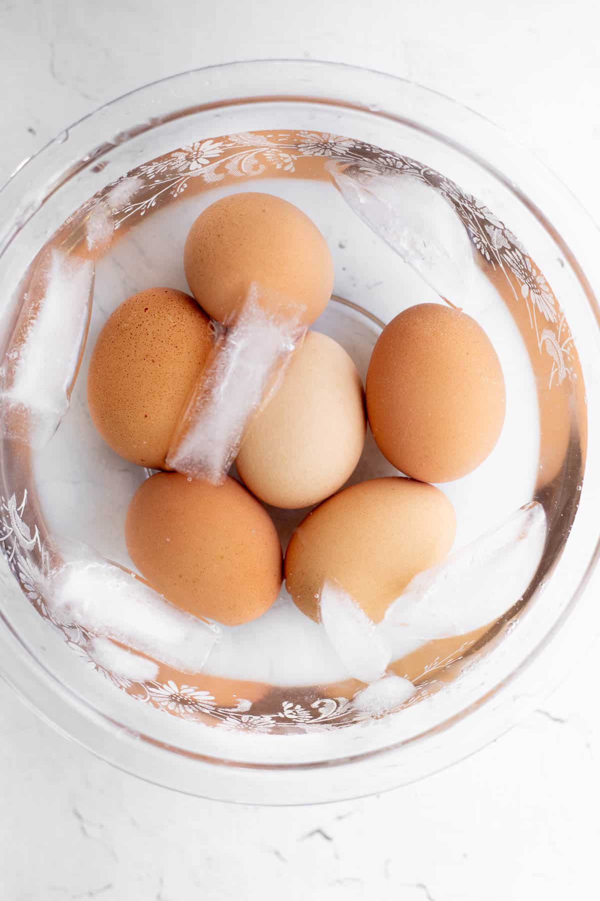 6 brown eggs in an ice bath.