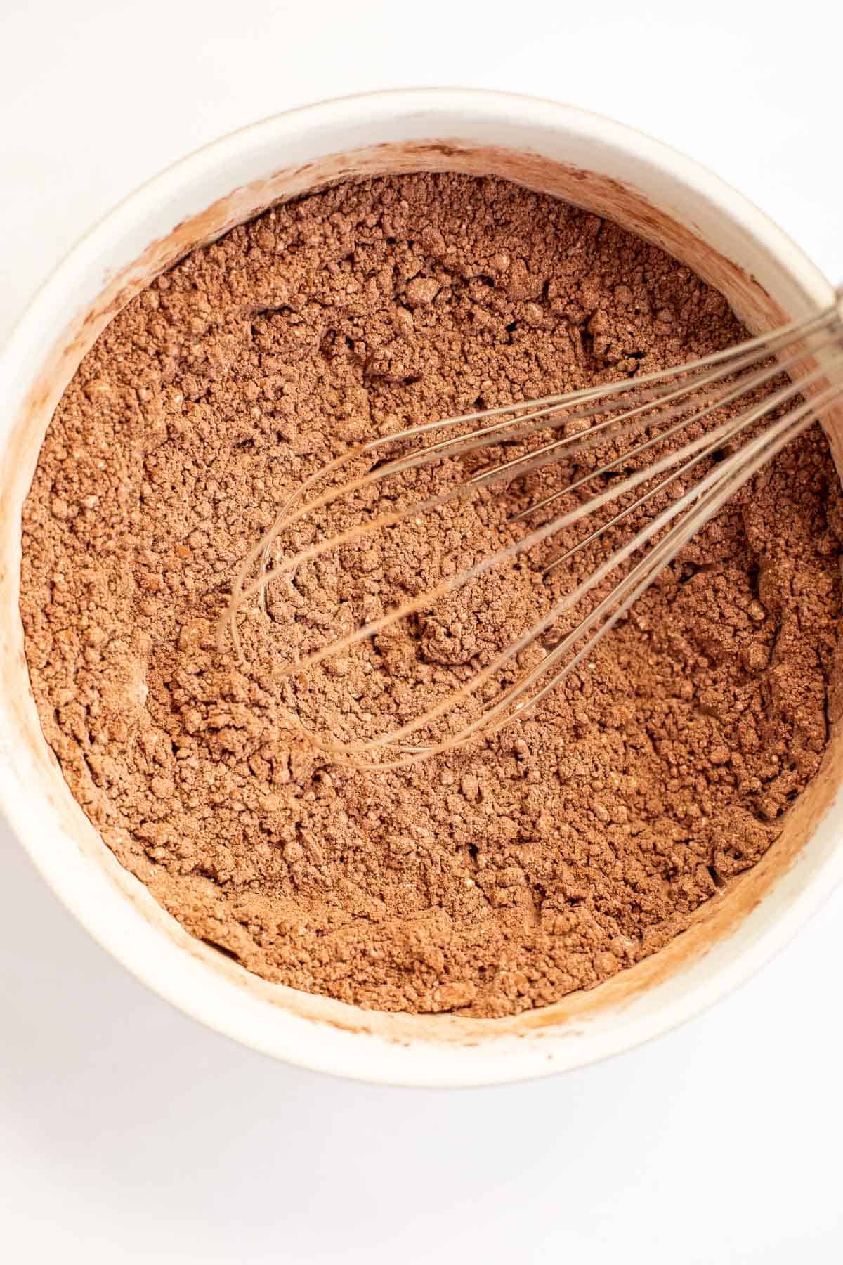 powdered sugar and cocoa powder whisked together in a white bowl.