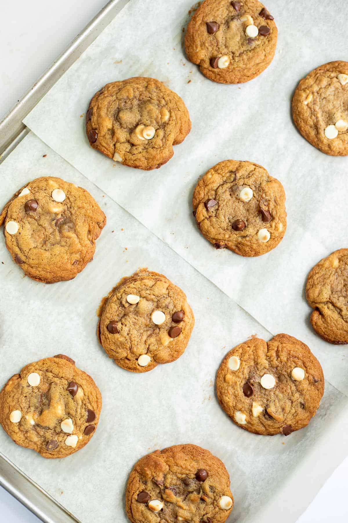 baked maple syrup chocolate chip cookies on a parchment lined baking sheet.