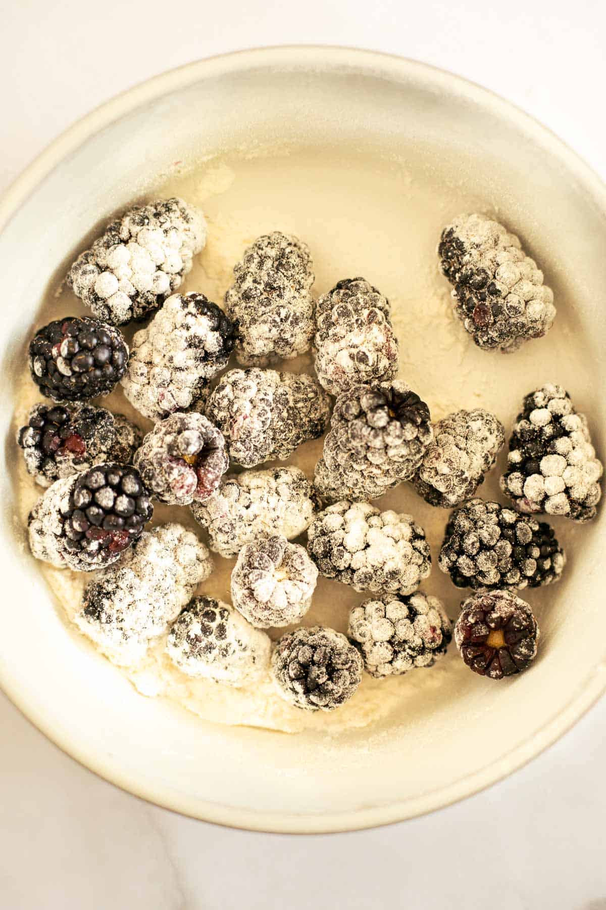 blackberries tossed with flour in a white bowl.