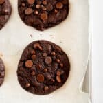 baked chocolate cookies without eggs on a parchment lined baking sheet.