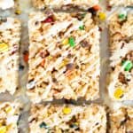 overhead shot of rice krispie treats with M&Ms on parchment paper.