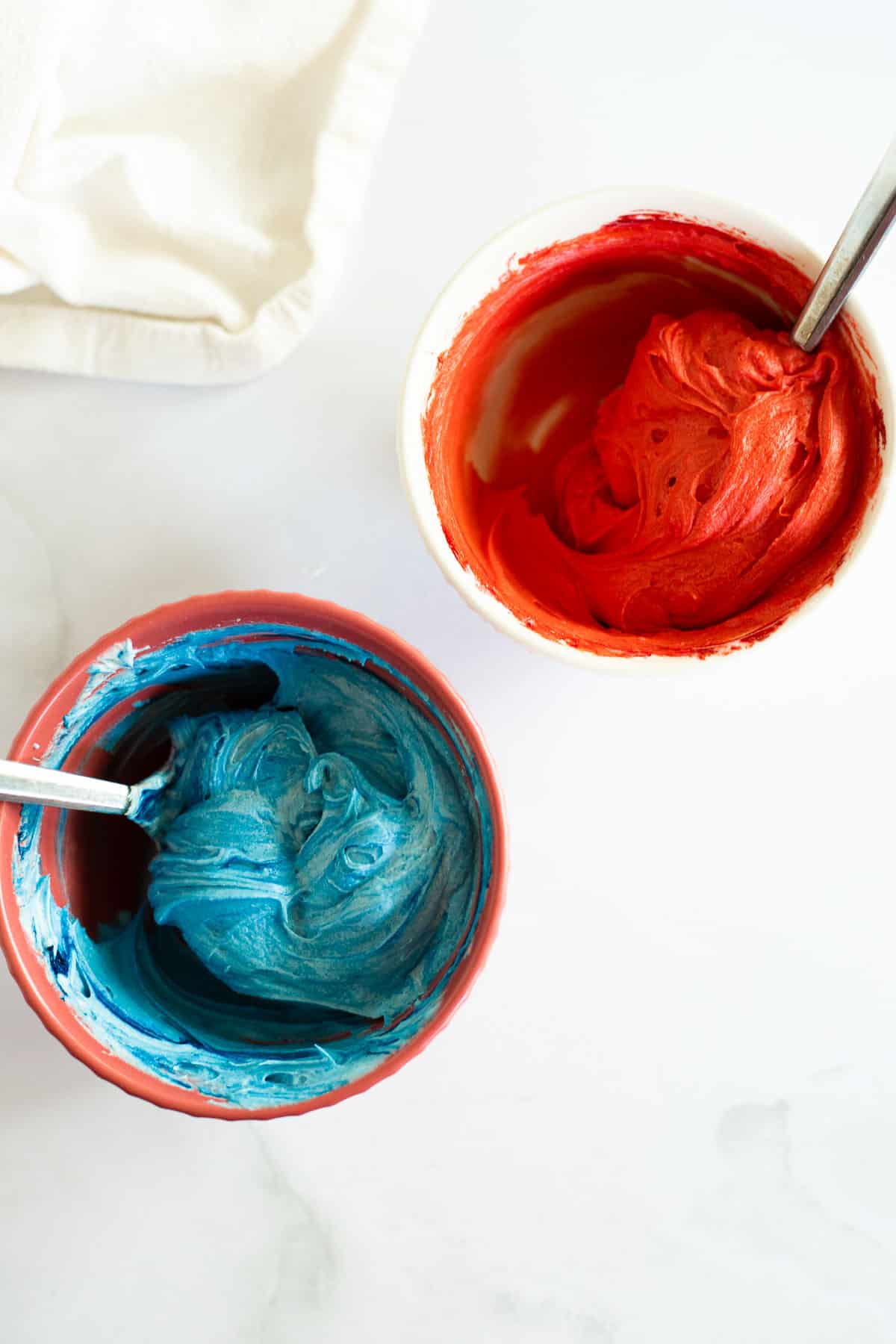 two small bowls of icing dyed red and blue.