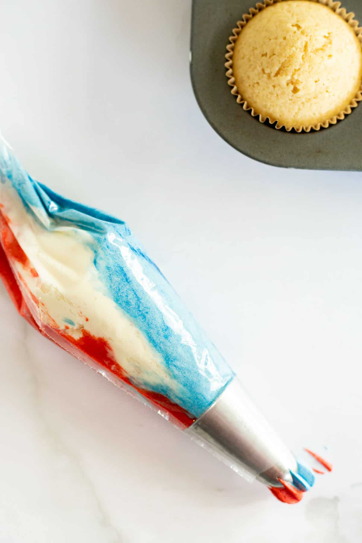red, white, and blue frosting in a piping bag.