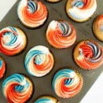 vanilla cupcakes with red, white, and blue frosting in a cupcake pan.