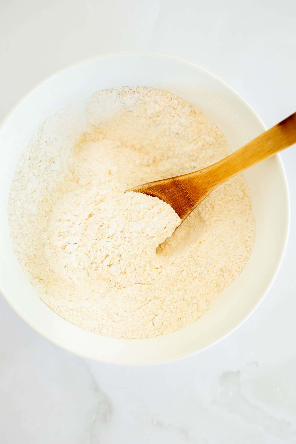 flour, sugar, salt, and baking powder mixed together in a white bowl.