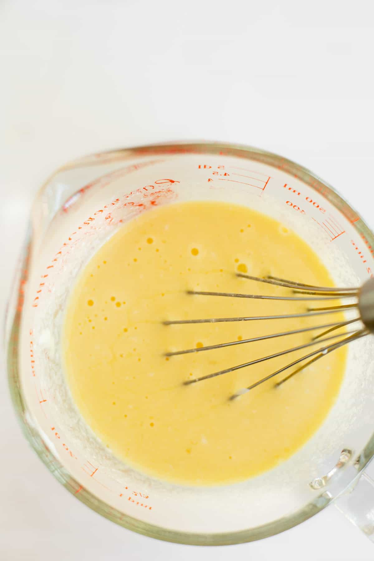 milk, eggs, sour cream, and vanilla extracted whisked together in a glass measuring cup.